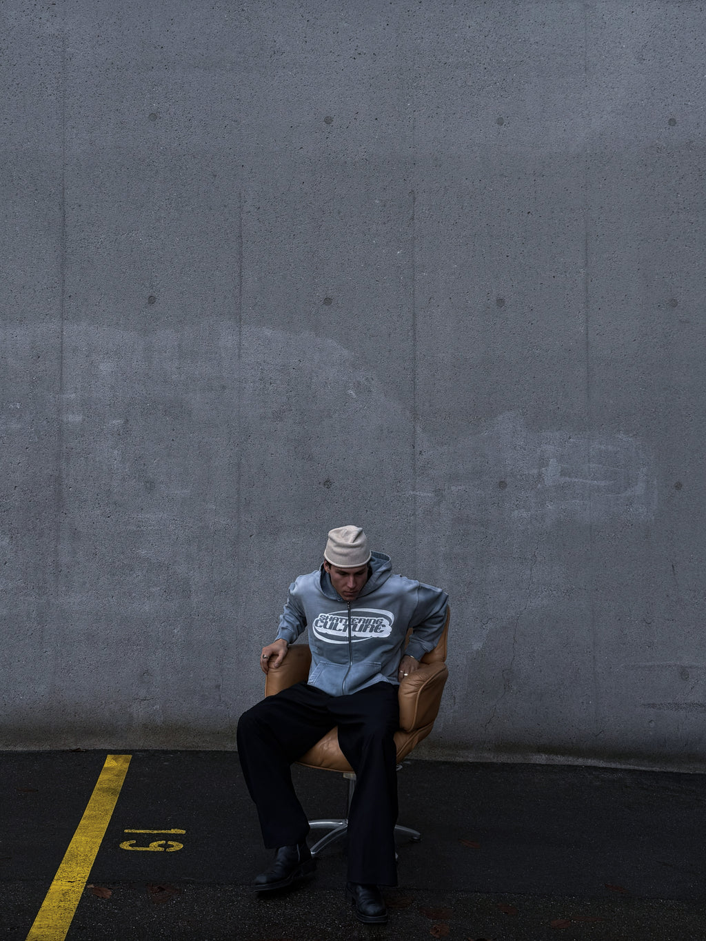 Model wearing ShatteringCulture SUNFADED ZIPPER sitting on chair